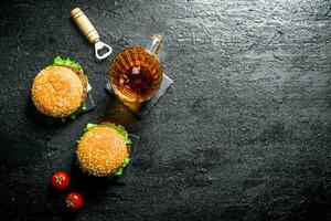 hamburguesas con cerveza en un vaso y Tomates. foto