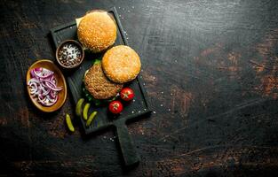 Burgers with spices and chopped onions in bowls. photo