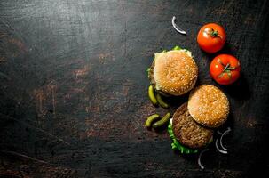 Burgers with gherkins and tomatoes. photo