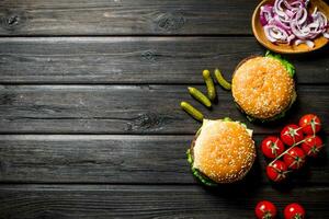 hamburguesas con tomates, pepinos y cebolla rebanadas en bol. foto