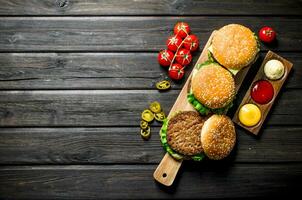 Burgers with different sauces,jalapenos and tomatoes. photo