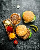 Burger with beer, sauces and gherkins. photo