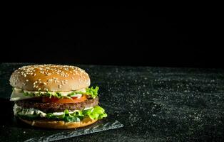 hamburguesa con jugoso carne, tomates y ensalada. foto