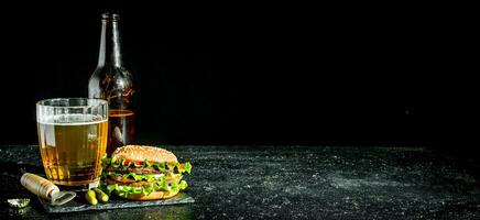 Beef Burger and beer in a glass and bottle. photo