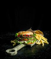 Burger with fries on the cutting Board. photo