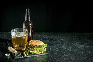 carne de vaca hamburguesa y cerveza en un vaso y botella. foto