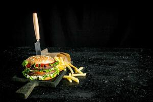 Burger with a knife and fries. photo