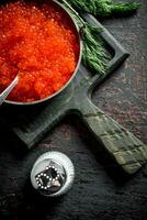 Red caviar in bowl with spoon, dill and salt. photo