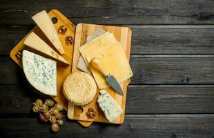 Assortment of different cheeses with grapes and walnuts. photo