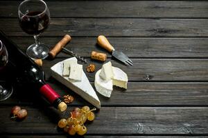 Brie cheese with red wine, nuts and grapes. photo