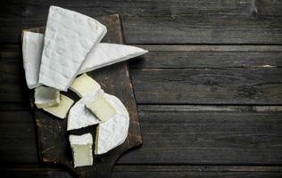 queso Brie queso en el el cortar tablero. foto