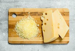Fresh grated cheese on a wooden Board. photo