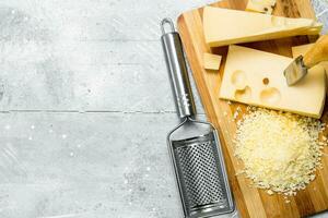 Fresh grated cheese on a chopping Board. photo