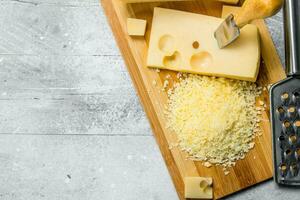 Fresh grated cheese on a wooden Board. photo