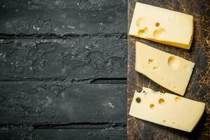 Fresco piezas de queso en el tablero. foto
