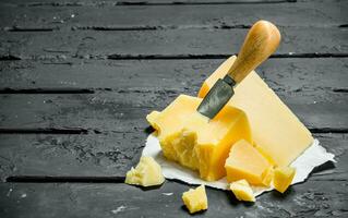 Parmesan cheese on paper with a knife. photo