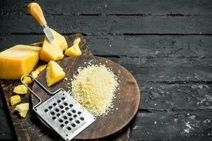 Grated Parmesan cheese on a wooden Board. photo