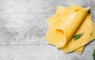 Thin slices of cheese with a branch of rosemary. photo