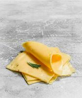 Thin slices of cheese with a branch of rosemary. photo