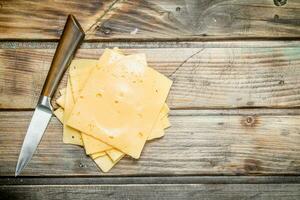 Delgado rebanadas de queso con un cuchillo. foto