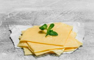 Delgado rebanadas de queso con un rama de menta. foto