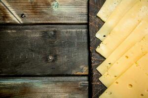 Thin slices of cheese on the cutting Board. photo