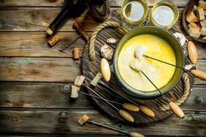 Delicious fondue cheese with olives and white wine. photo