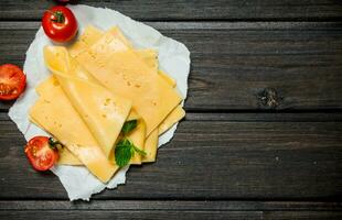 Thin slices of cheese with tomatoes and a branch of mint. photo