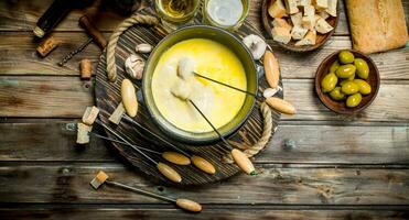 Delicious fondue cheese with olives and white wine. photo