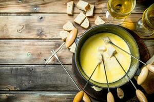 delicioso fondue queso con un pan rebanadas y blanco vino. foto