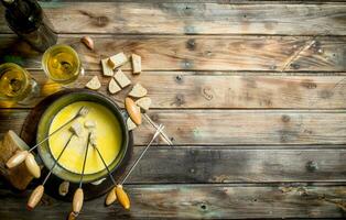 Delicious fondue cheese with bread slices and white wine. photo