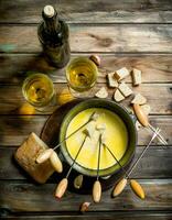 Delicious fondue cheese with bread slices and white wine. photo