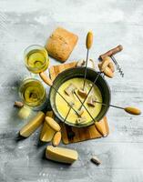 delicioso fondue queso con un pan y blanco vino foto