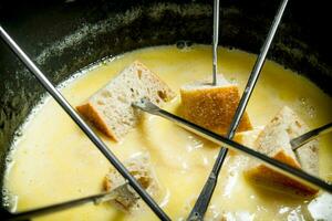 Delicious fondue cheese with slices of bread . photo