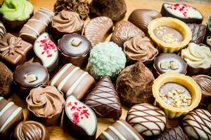 Chocolate candies with nuts and various fillings. photo