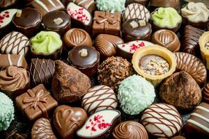 Chocolate candies with nuts and various fillings. photo