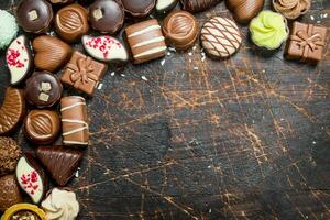 Chocolate sweets with nuts and various fillings. photo