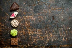 Chocolate sweets with nuts and various fillings. photo