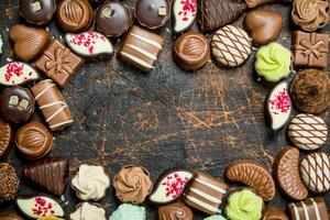 Chocolate sweets with nuts and various fillings. photo