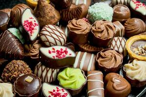 Chocolate candies with nuts and various fillings. photo