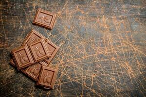 Chocolate wedges on wooden background. photo