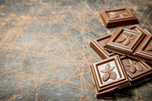 Chocolate wedges on wooden background. photo