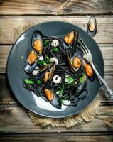Mediterranean food. Spaghetti with cuttlefish black ink and clams. photo