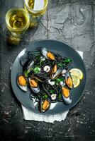 Mediterranean food. Spaghetti with cuttlefish ink, clams and white wine. photo