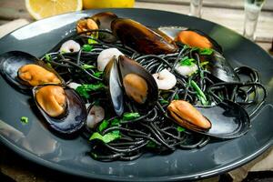 Mediterranean food. Spaghetti with cuttlefish black ink and clams. photo