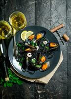 Mediterranean food. Spaghetti with cuttlefish ink, clams and white wine. photo