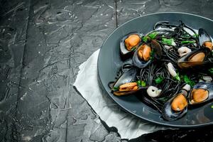 Mediterranean food. Spaghetti with cuttlefish ink and clams. photo