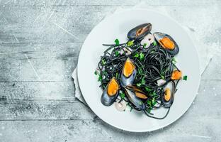 Mediterranean pasta. Spaghetti with cuttlefish ink and clams. photo