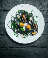 Mediterranean food. Spaghetti with cuttlefish ink and clams. photo