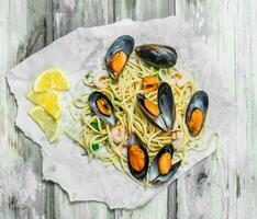 Mediterranean pasta. Spaghetti seafood with clams on paper. photo